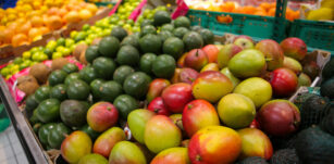 Mangos, avocados, limes, grapefruits, oranges and coconuts on the fruits and vegetables aisle in a store.